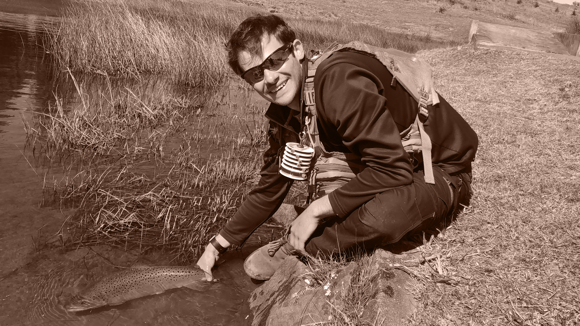 Lanzo letting a fish go he caught with fly fishing